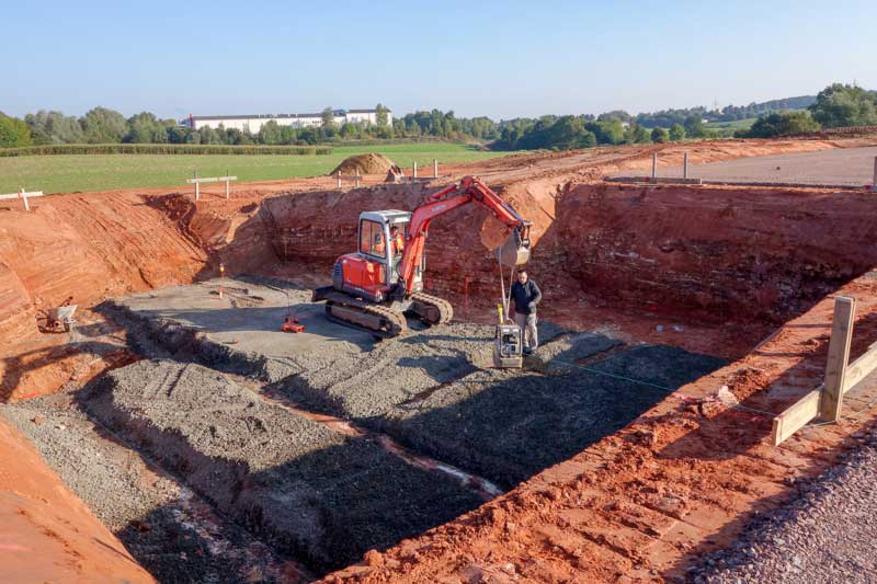 Die Baugrube für den Keller ist ausgehoben und der Untergrund wird befestigt / © 2013 Arche KaNaum (NH)