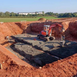 Die Baugrube für den Keller ist ausgehoben und der Untergrund wird befestigt / © 2013 Arche KaNaum (NH)