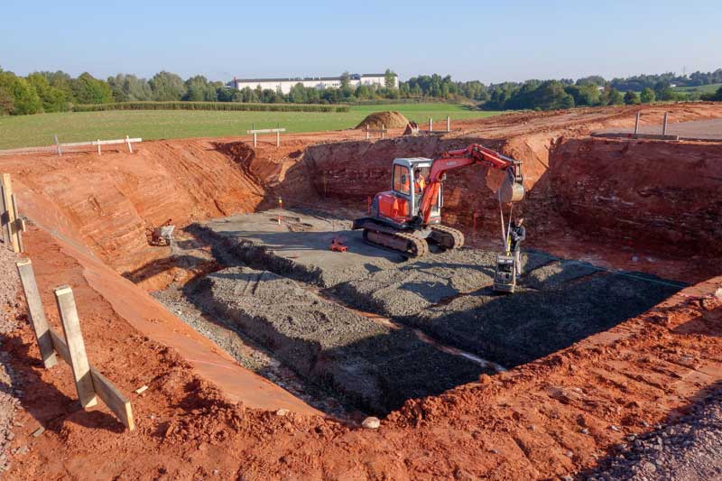 Die Baugrube für den Keller ist ausgehoben und der Untergrund wird befestigt / © 2013 Arche KaNaum (NH)