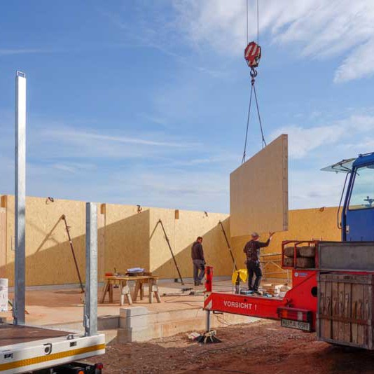 Die vorgefertigten Außenwände unseres Wirtschaftsgebäudes werden aufgestellt Die vorgefertigten Außenwände unseres Wirtschaftsgebäudes werden aufgestellt / © 2014 Arche KaNaum (NH)