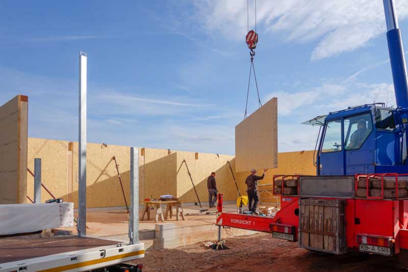 Die vorgefertigten Außenwände unseres Wirtschaftsgebäudes werden aufgestellt / © 2014 Arche KaNaum (NH)