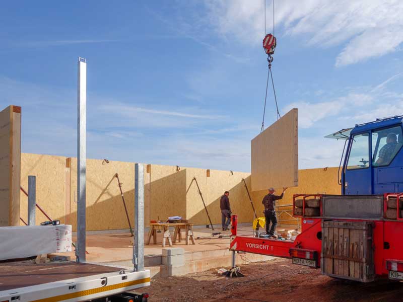 Die vorgefertigten Außenwände unseres Wirtschaftsgebäudes werden aufgestellt / © 2014 Arche KaNaum (NH)